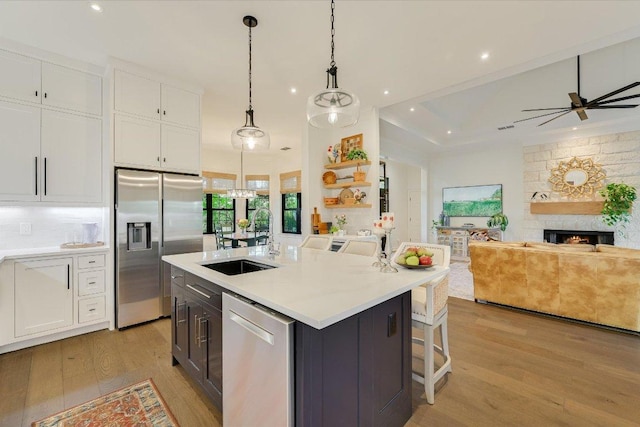 3342 Far View Dr, Austin, TX 78730 - kitchen featuring stainless steel appliances, light wood-style flooring, white cabinetry, open floor plan, and light countertops