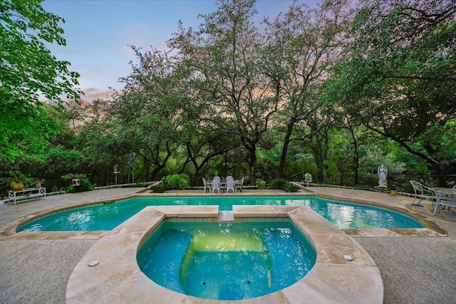 9105 Westminster Glen Ave, Austin, TX 78730 - view of swimming pool with outdoor dining space, a patio, view of wooded area, and a pool with connected hot tub