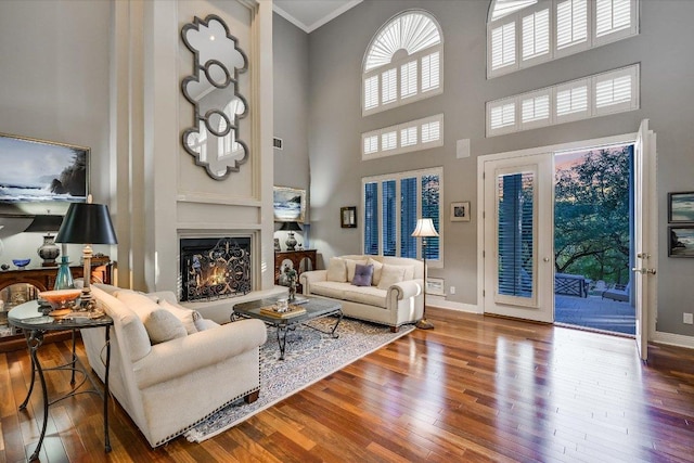 9105 Westminster Glen Ave, Austin, TX 78730 - living area featuring a high ceiling, wood finished floors, a warm lit fireplace, and crown molding