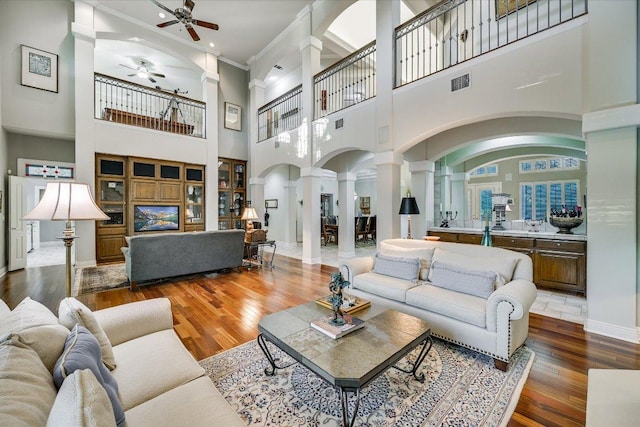 9105 Westminster Glen Ave, Austin, TX 78730 - living area with decorative columns, ceiling fan, crown molding, arched walkways, and wood finished floors