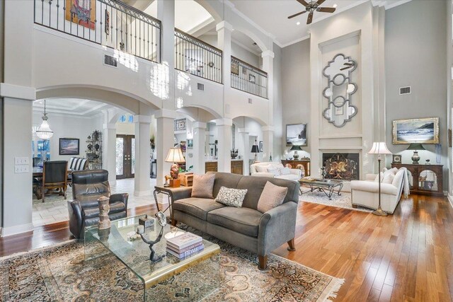 9105 Westminster Glen Ave, Austin, TX 78730 - living area with ornate columns, arched walkways, a high ceiling, hardwood / wood-style floors, and ceiling fan
