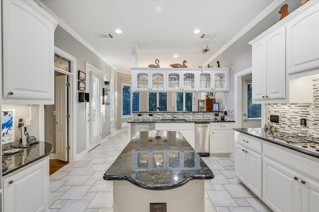 9105 Westminster Glen Ave, Austin, TX 78730 - kitchen with backsplash, glass insert cabinets, white cabinets, crown molding, and dark stone counters
