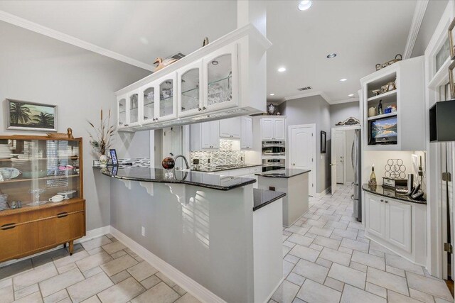 9105 Westminster Glen Ave, Austin, TX 78730 - kitchen featuring a peninsula, ornamental molding, white cabinets, glass insert cabinets, and appliances with stainless steel finishes