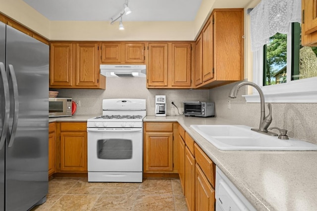 6712 Shiner St, Austin, TX 78729 - kitchen featuring appliances with stainless steel finishes, under cabinet range hood, light countertops, and brown cabinetry
