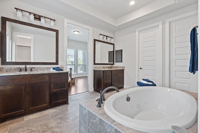 164 Mary Cornelia Cv, Buda, TX 78610 - full bath featuring a jetted tub, two vanities, and recessed lighting