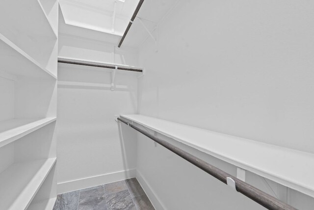 164 Mary Cornelia Cv, Buda, TX 78610 - walk in closet with dark stone finish flooring