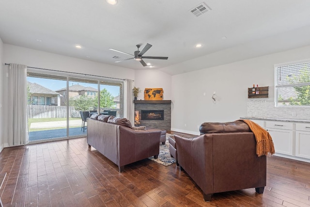 164 Mary Cornelia Cv, Buda, TX 78610 - living area with dark wood-type flooring, a stone fireplace, a ceiling fan, recessed lighting, and vaulted ceiling