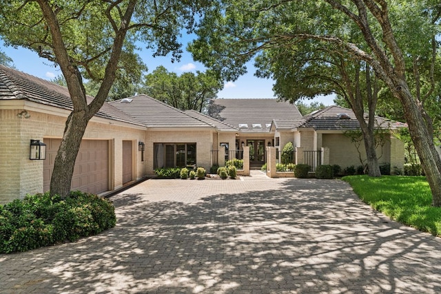 59 Stillmeadow Dr, The Hills, TX 78738 - view of front of house with a garage, decorative driveway, french doors, brick siding, and a tile roof