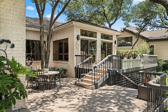 59 Stillmeadow Dr, The Hills, TX 78738 - back of property featuring brick siding, outdoor dining space, and a deck