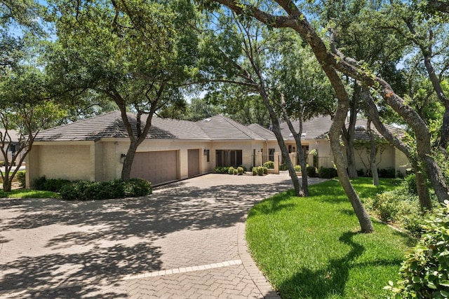 59 Stillmeadow Dr, The Hills, TX 78738 - view of front facade with curved driveway, an attached garage, and brick siding