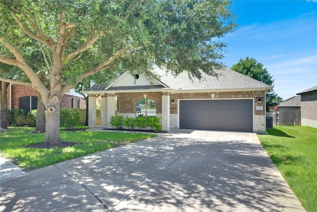 1086 Sussex Way, Round Rock, TX 78665 - view of front of house with an attached garage, driveway, stone siding, a shingled roof, and brick siding