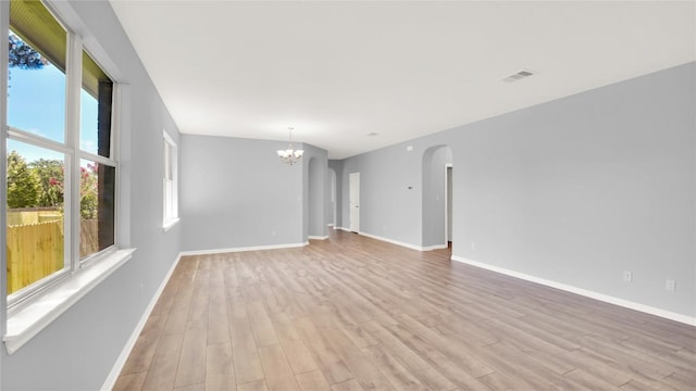 1086 Sussex Way, Round Rock, TX 78665 - unfurnished room with healthy amount of natural light, light wood-style flooring, and arched walkways