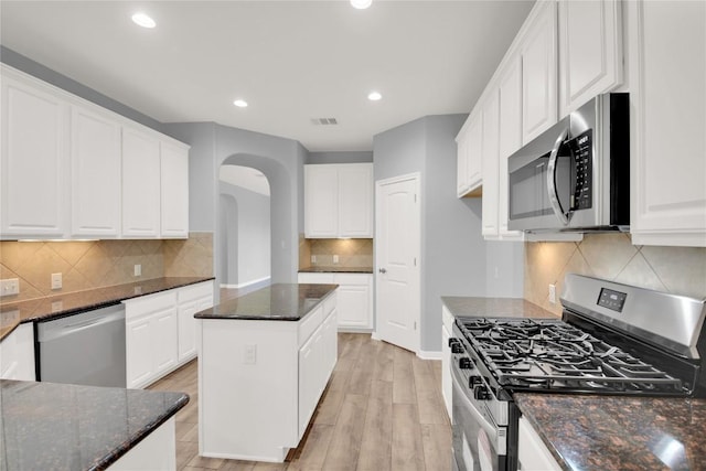 1086 Sussex Way, Round Rock, TX 78665 - kitchen featuring appliances with stainless steel finishes, arched walkways, dark stone countertops, decorative backsplash, and recessed lighting