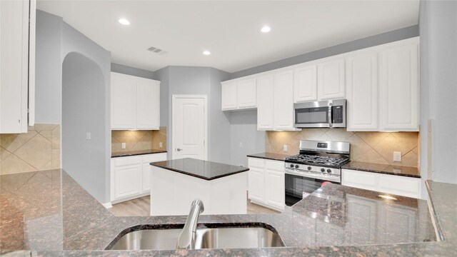 1086 Sussex Way, Round Rock, TX 78665 - kitchen with appliances with stainless steel finishes, dark stone countertops, backsplash, recessed lighting, and white cabinets