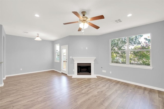 1086 Sussex Way, Round Rock, TX 78665 - unfurnished living room featuring ceiling fan, light wood finished floors, a fireplace with raised hearth, and recessed lighting