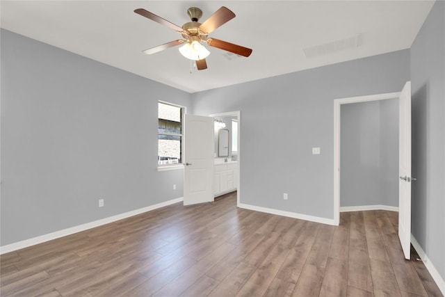 1086 Sussex Way, Round Rock, TX 78665 - unfurnished bedroom with wood finished floors, a ceiling fan, and ensuite bath