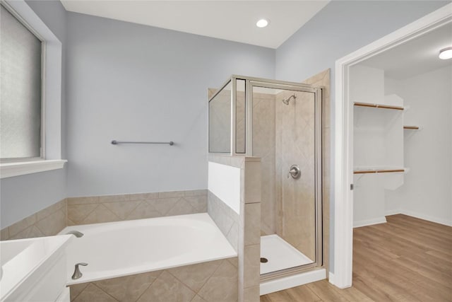 1086 Sussex Way, Round Rock, TX 78665 - bathroom with a bath, a stall shower, a spacious closet, wood finished floors, and recessed lighting