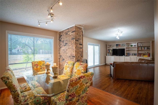 8403 Ardash Ln, Austin, TX 78759 - dining space featuring wood finished floors, a textured ceiling, and rail lighting