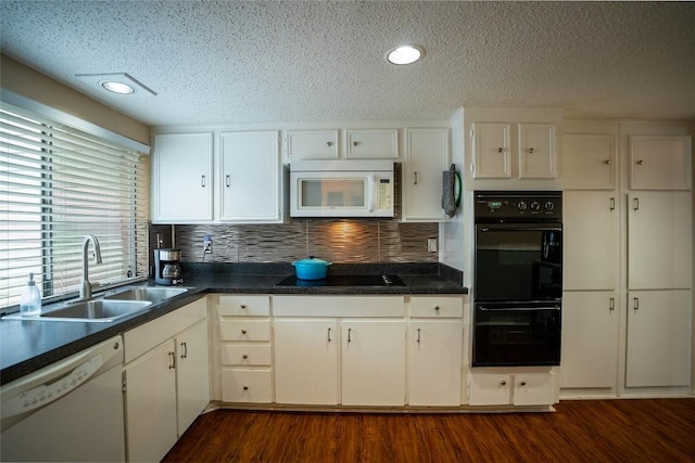 8403 Ardash Ln, Austin, TX 78759 - kitchen with black appliances, a textured ceiling, dark countertops, decorative backsplash, and recessed lighting
