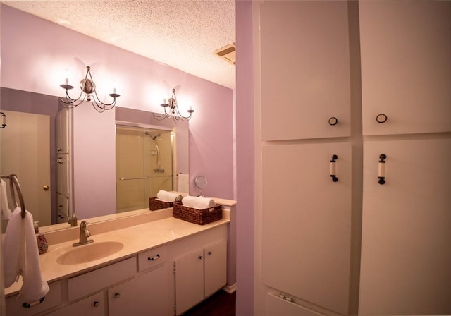 8403 Ardash Ln, Austin, TX 78759 - bathroom featuring a shower stall, vanity, and a textured ceiling