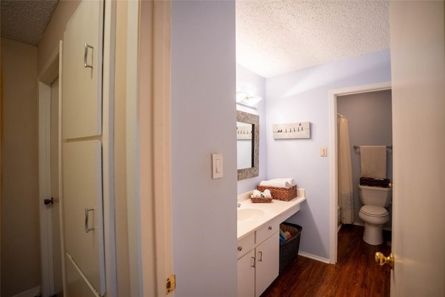 8403 Ardash Ln, Austin, TX 78759 - bathroom featuring a textured ceiling, wood finished floors, vanity, and curtained shower