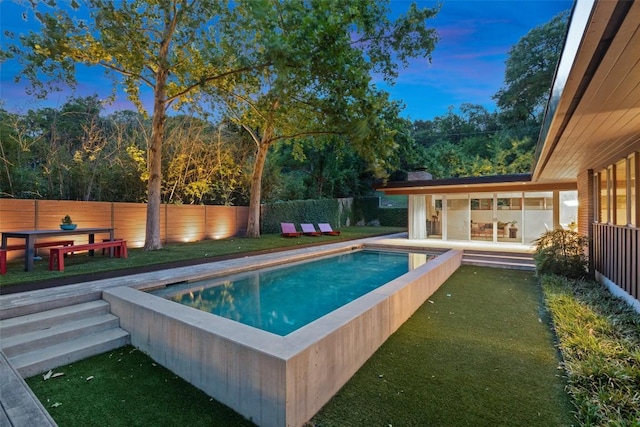 4506 Crestway Dr, Austin, TX 78731 - pool at dusk with a fenced backyard and view of wooded area