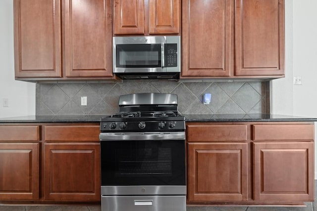 20936 Prestwick Dr, Hutto, TX 78634 - kitchen featuring stainless steel appliances, dark stone countertops, backsplash, and brown cabinets