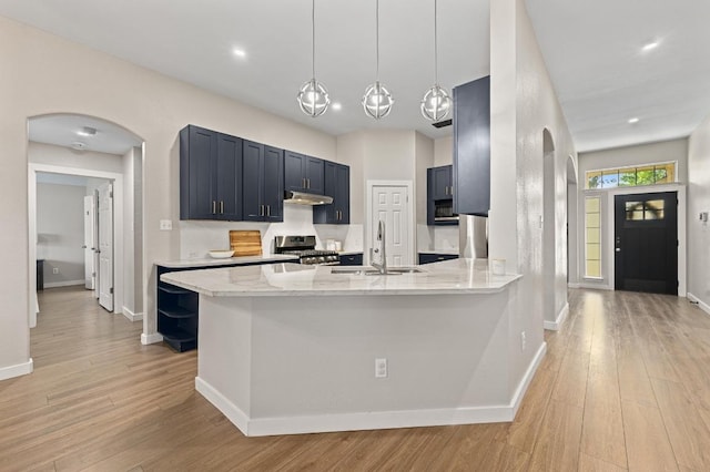 101 Desert Highlands Trl, Round Rock, TX 78665 - kitchen featuring arched walkways, stainless steel range with gas cooktop, light wood-style flooring, and recessed lighting