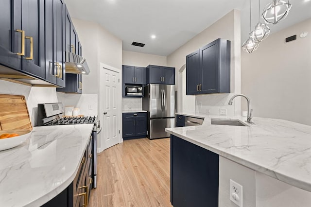 101 Desert Highlands Trl, Round Rock, TX 78665 - kitchen featuring stainless steel appliances, extractor fan, light wood-style floors, light stone counters, and recessed lighting
