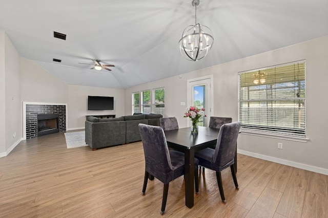 101 Desert Highlands Trl, Round Rock, TX 78665 - dining space with a chandelier, a ceiling fan, lofted ceiling, light wood-style flooring, and a fireplace