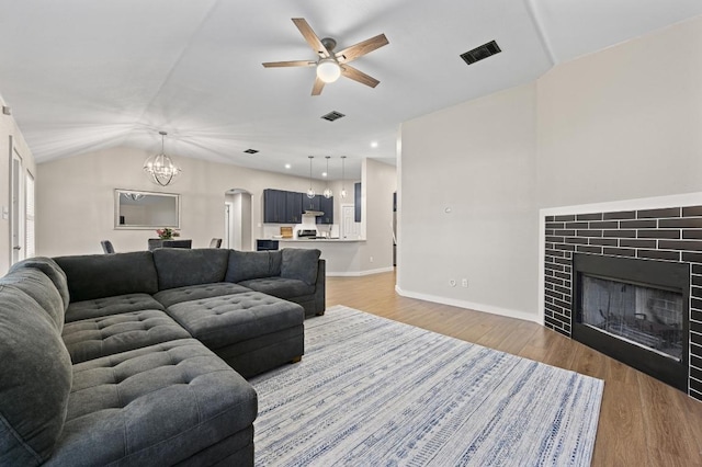 101 Desert Highlands Trl, Round Rock, TX 78665 - living room featuring ceiling fan, a tiled fireplace, wood finished floors, a chandelier, and lofted ceiling