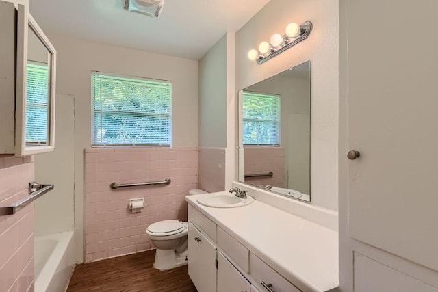 4805 Hilldale Dr, Austin, TX 78723 - full bath featuring tile walls, wood finished floors, a bath, vanity, and a wainscoted wall