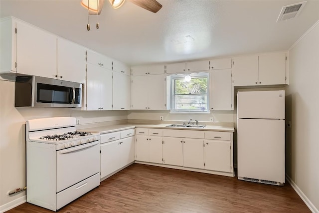 4805 Hilldale Dr, Austin, TX 78723 - kitchen featuring white appliances, white cabinets, wood finished floors, and ceiling fan