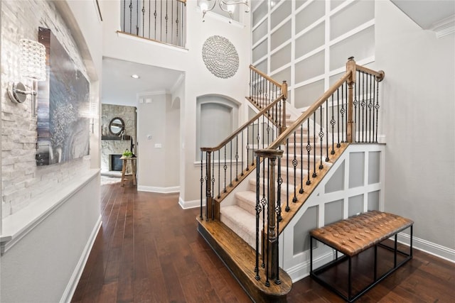 108 Kildrummy Ln, Lakeway, TX 78738 - stairway with hardwood / wood-style floors, a high ceiling, a chandelier, a fireplace, and ornamental molding