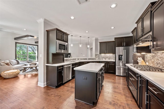 108 Kildrummy Ln, Lakeway, TX 78738 - kitchen featuring appliances with stainless steel finishes, ornamental molding, light countertops, tasteful backsplash, and open floor plan