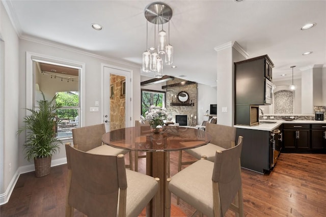 108 Kildrummy Ln, Lakeway, TX 78738 - dining space with plenty of natural light, dark wood finished floors, crown molding, a stone fireplace, and recessed lighting