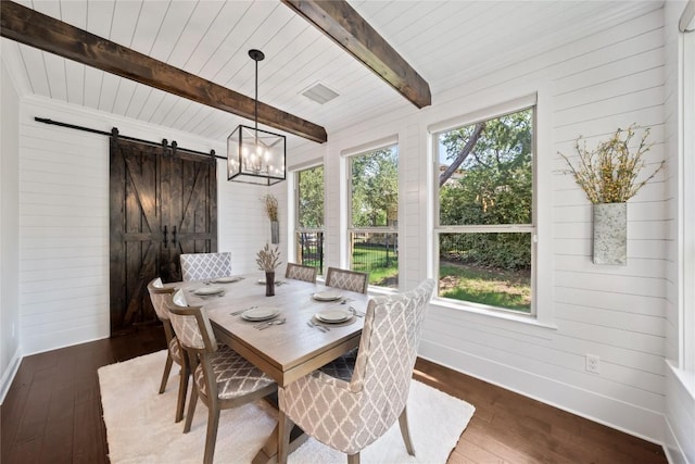 108 Kildrummy Ln, Lakeway, TX 78738 - dining space featuring a barn door, wood-type flooring, wood walls, a chandelier, and a wooden ceiling with exposed beams