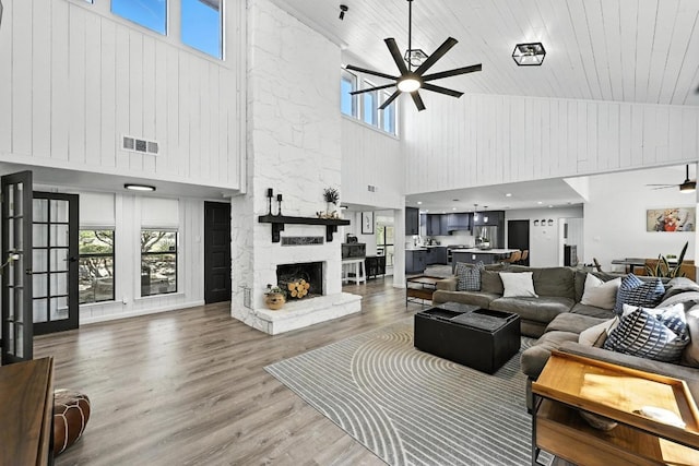 11803 Jess Dr, Austin, TX 78737 - living area with high vaulted ceiling, a ceiling fan, a stone fireplace, healthy amount of natural light, and light wood finished floors