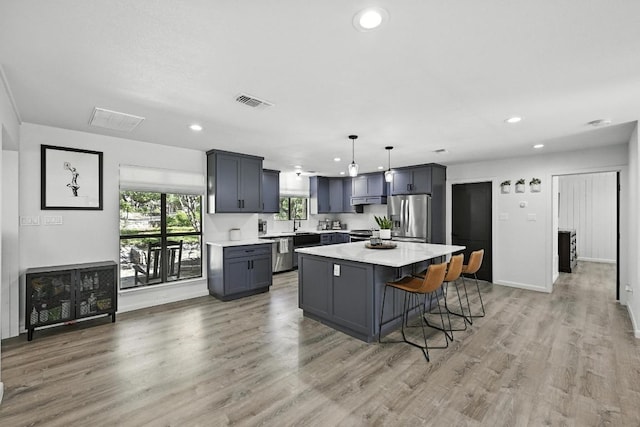 11803 Jess Dr, Austin, TX 78737 - kitchen with stainless steel appliances, light countertops, a center island, exhaust hood, and recessed lighting
