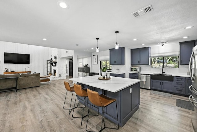 11803 Jess Dr, Austin, TX 78737 - kitchen with stainless steel dishwasher, a kitchen bar, a center island, recessed lighting, and light wood-style floors