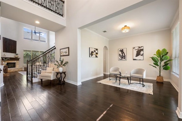 201 Montalcino Blvd, Austin, TX 78734 - living area featuring a stone fireplace, arched walkways, stairs, dark wood-type flooring, and a towering ceiling