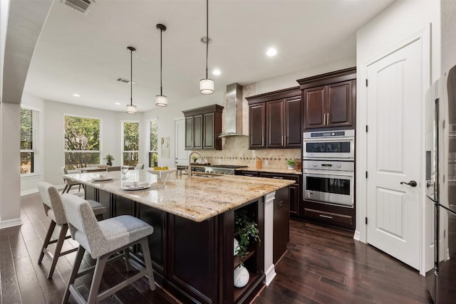 201 Montalcino Blvd, Austin, TX 78734 - kitchen with wall chimney exhaust hood, double oven, dark wood-style floors, a breakfast bar area, and backsplash