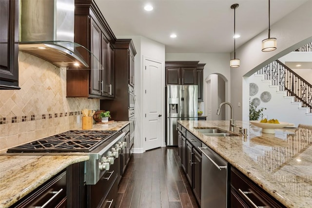 201 Montalcino Blvd, Austin, TX 78734 - kitchen featuring wall chimney range hood, appliances with stainless steel finishes, arched walkways, light stone counters, and dark brown cabinets