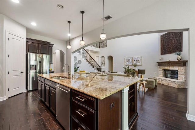 201 Montalcino Blvd, Austin, TX 78734 - kitchen with stainless steel appliances, arched walkways, open floor plan, a fireplace, and recessed lighting