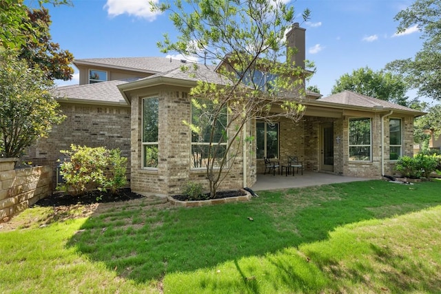 201 Montalcino Blvd, Austin, TX 78734 - back of house with a chimney, brick siding, a patio, a yard, and a shingled roof