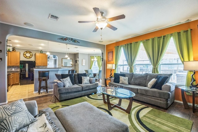 6401 Quinton Dr, Austin, TX 78747 - living room with a ceiling fan, arched walkways, and light wood finished floors