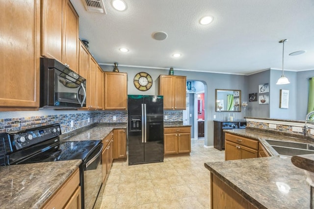6401 Quinton Dr, Austin, TX 78747 - kitchen with black appliances, crown molding, backsplash, arched walkways, and brown cabinetry