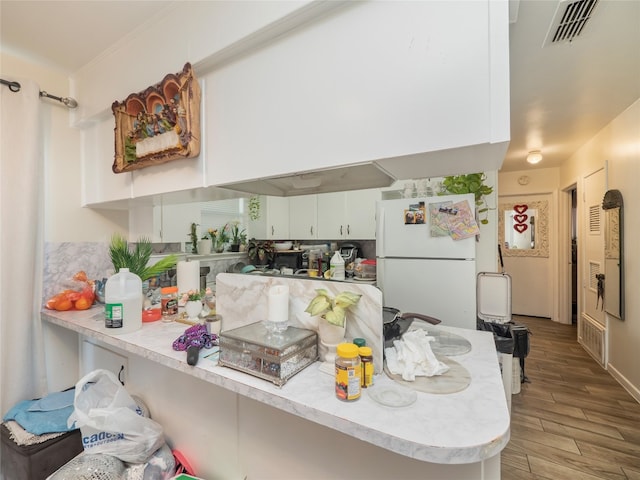 8508 Dryfield Dr, Austin, TX 78758 - kitchen with freestanding refrigerator, light countertops, white cabinetry, and light wood finished floors