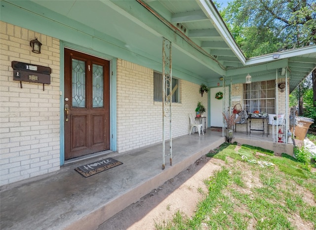 8508 Dryfield Dr, Austin, TX 78758 - doorway to property featuring covered porch and brick siding
