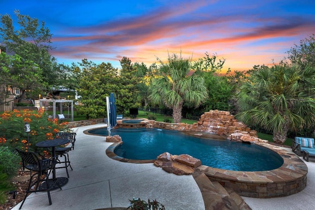 14417 Heron Bay Cv, Bee Cave, TX 78738 - pool at dusk featuring a patio and a pool with connected hot tub